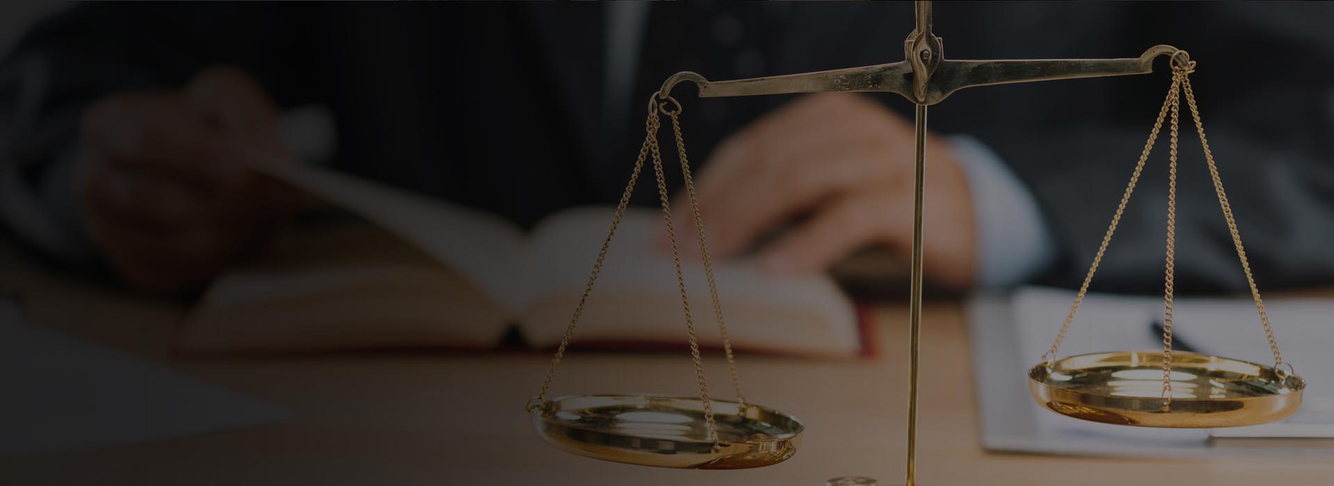 Scales of justice with lawyer reading in background